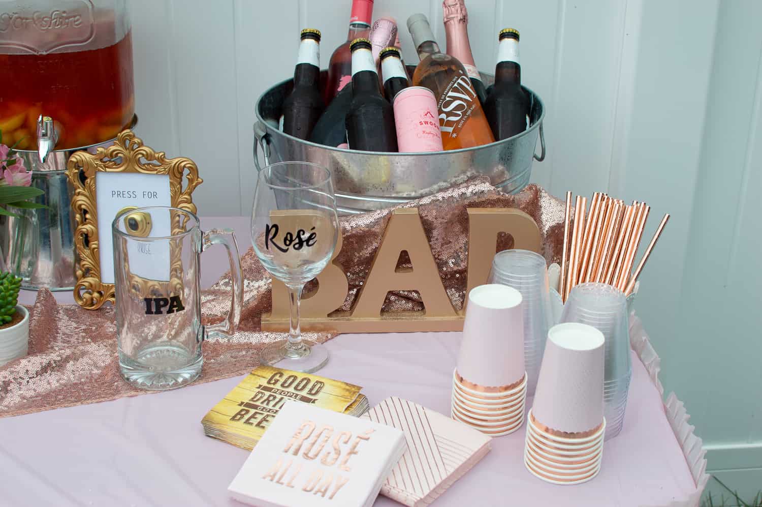 Set up a cute bar for a rosé wine bridal shower with rose gold party supplies