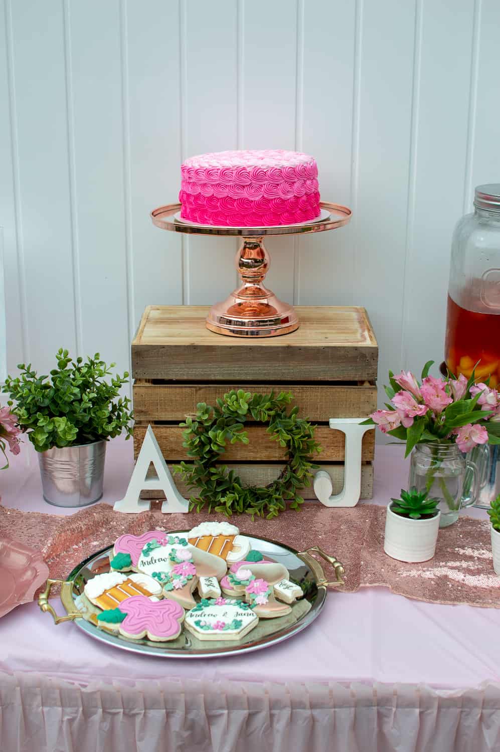 Pink rosette cake on Amalfi Decor cake stand and custom sugar cookies