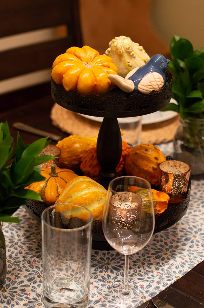 Create a lovely table centerpiece using a tiered tray, some gourds, candles, and little bird accent.