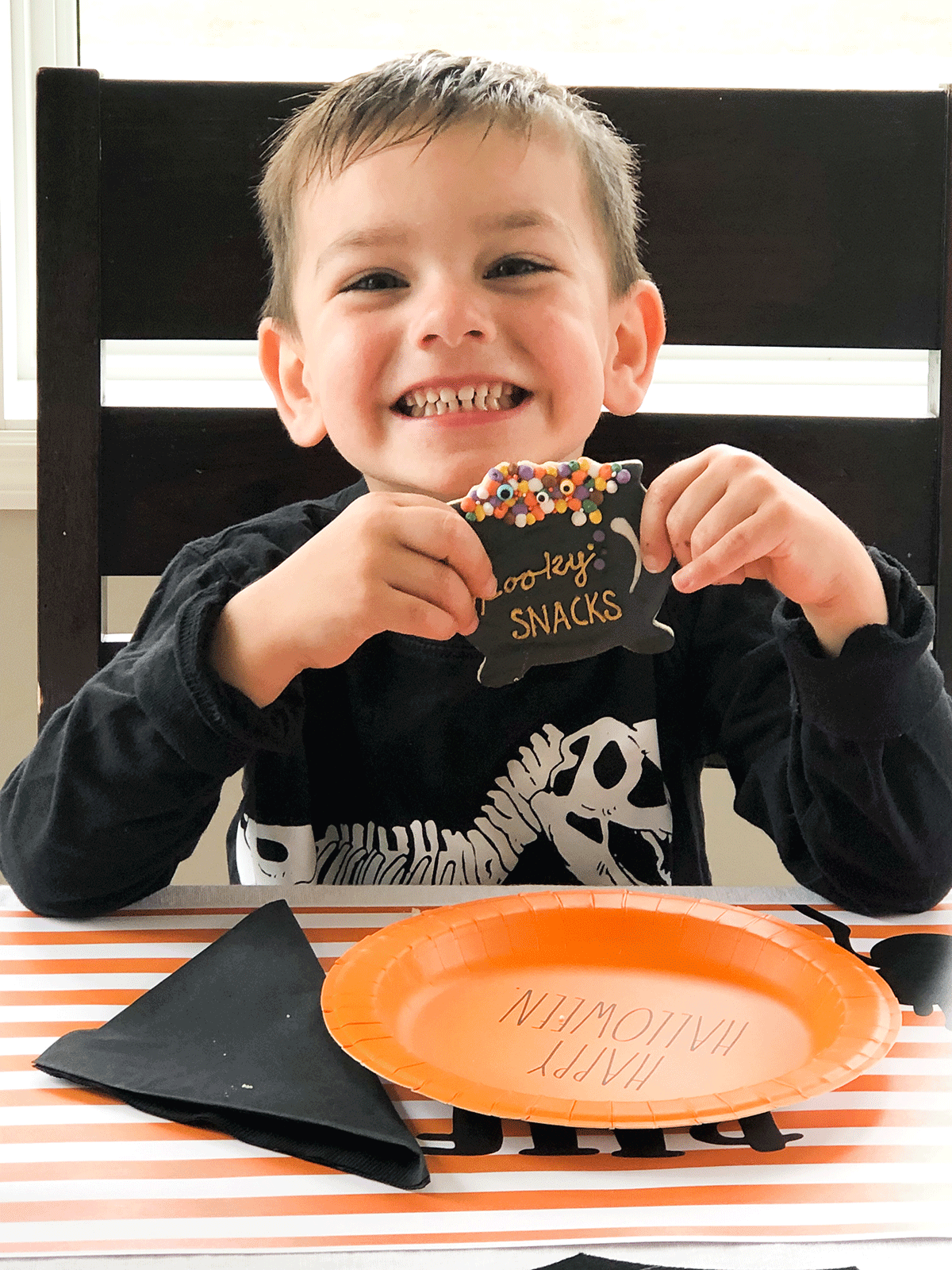 smiling child with Halloween sugar cookie