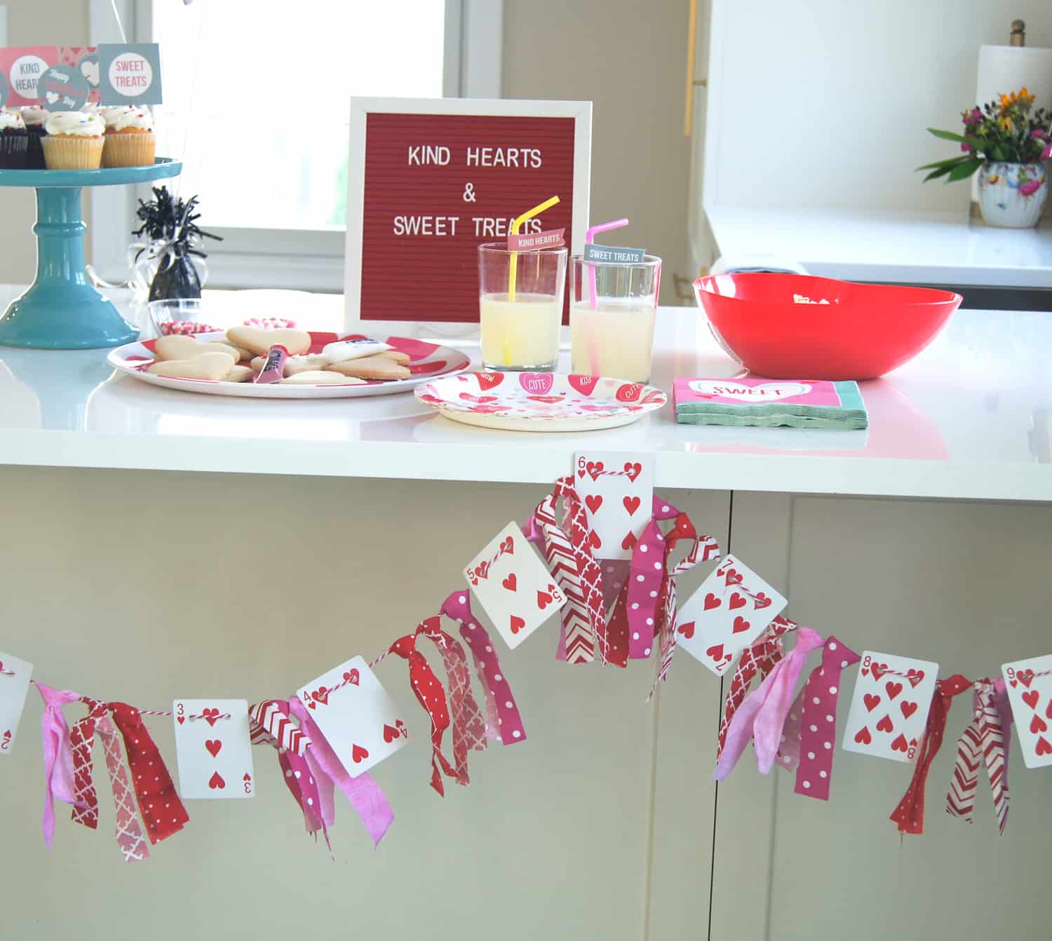 Valentine's play date food table with cupcakes, popcorn, and lemonade
