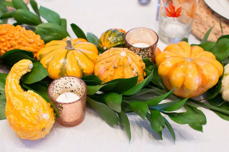 Use greenery and gourds to set a lush and vibrant Thanksgiving Table